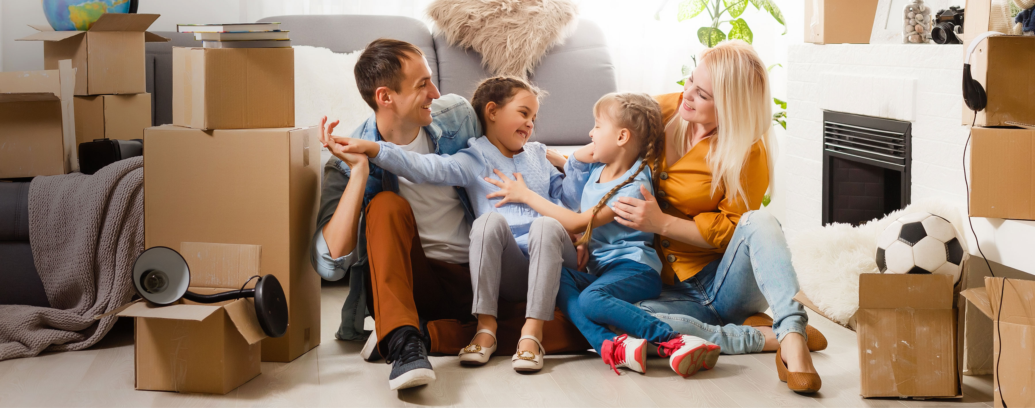 happy man women and two children in living room with moving boxes