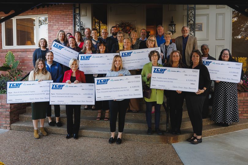 TCUF group photo holding checks