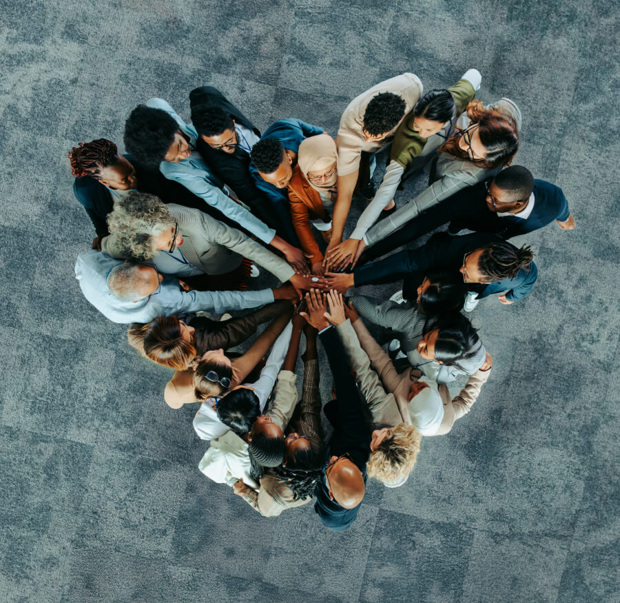 a group of people placing their hands in the center