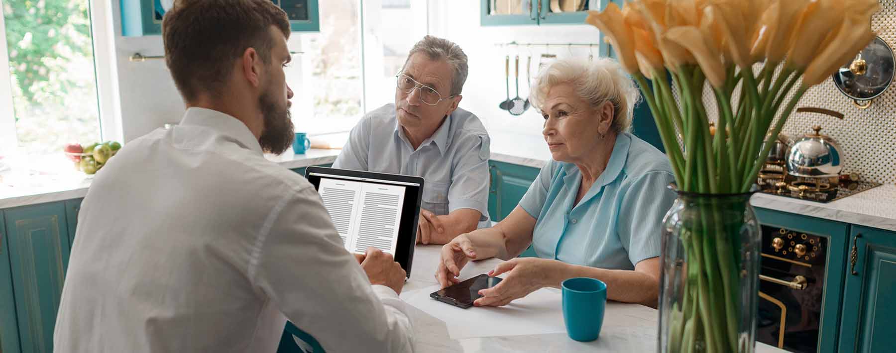 older couple meeting with financial advisor in their home