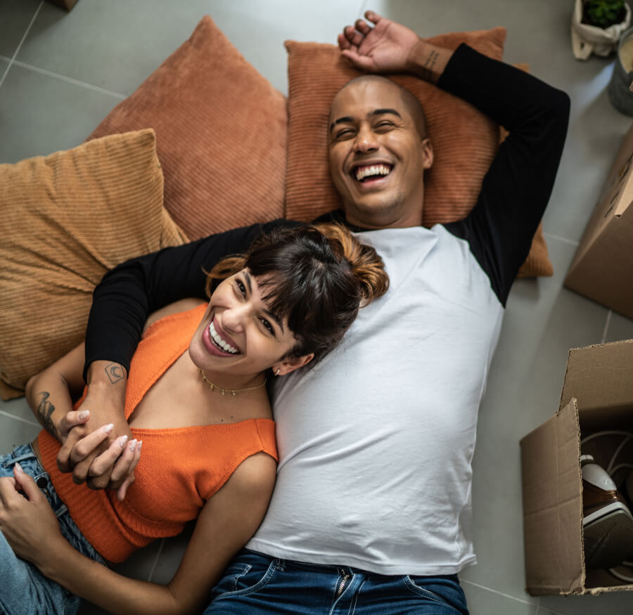 a couple laughing while laying on the floor