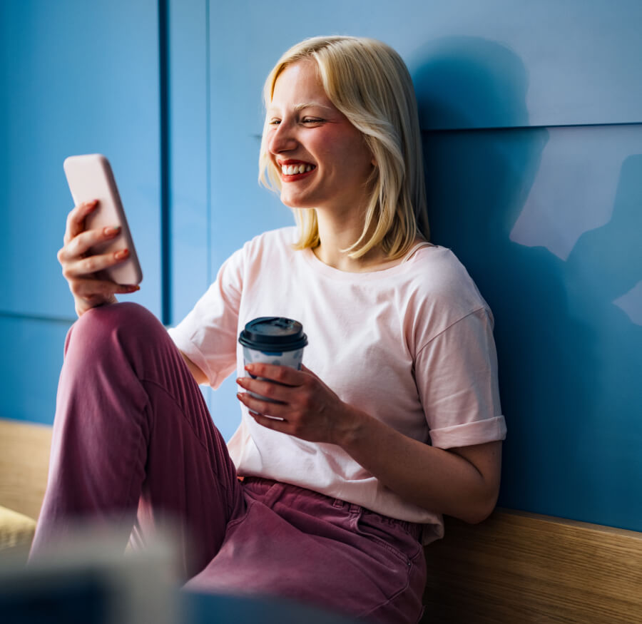 a woman smiling while checking her mobile device