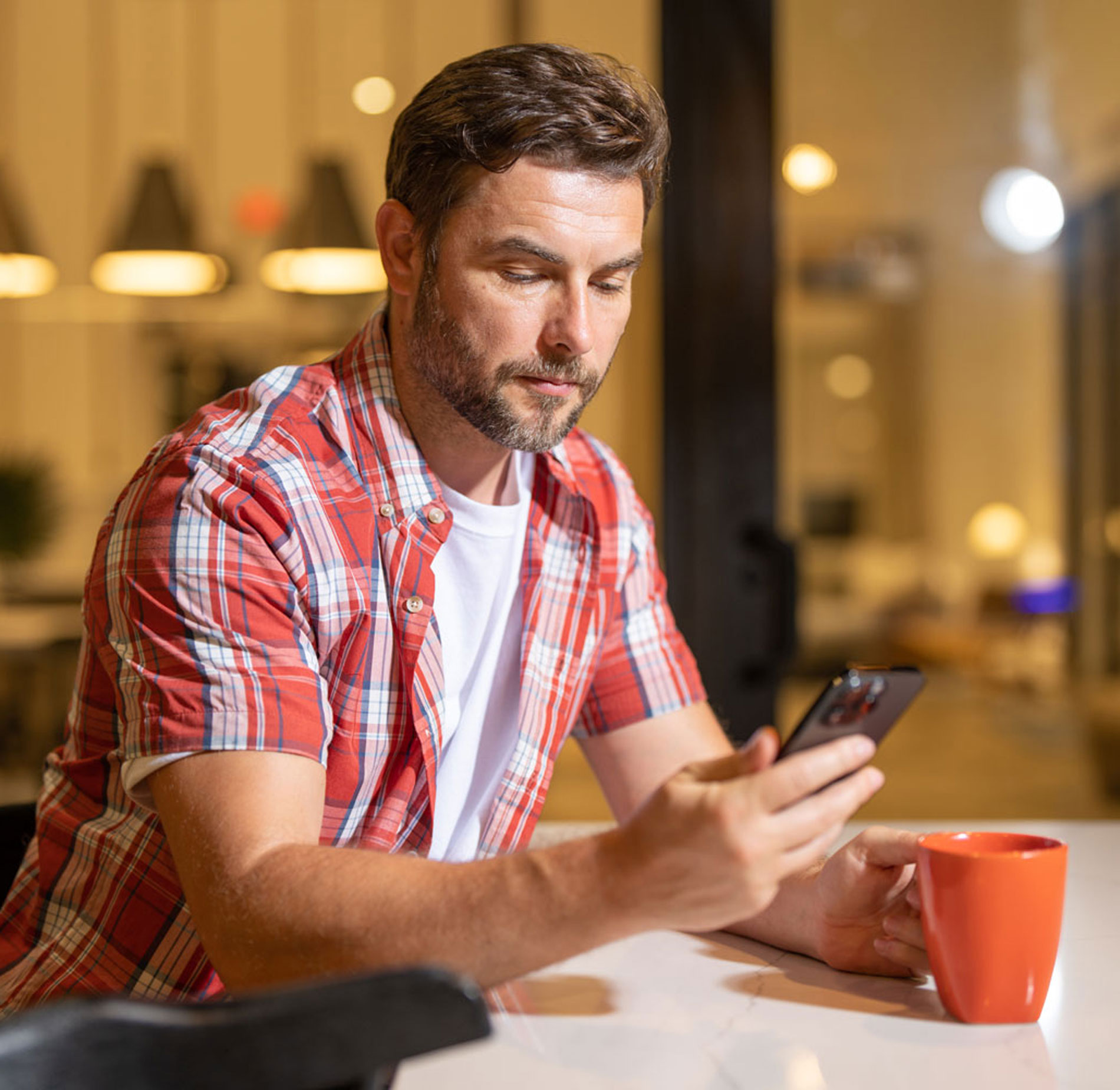 Man looking at cell phone in coffee shop