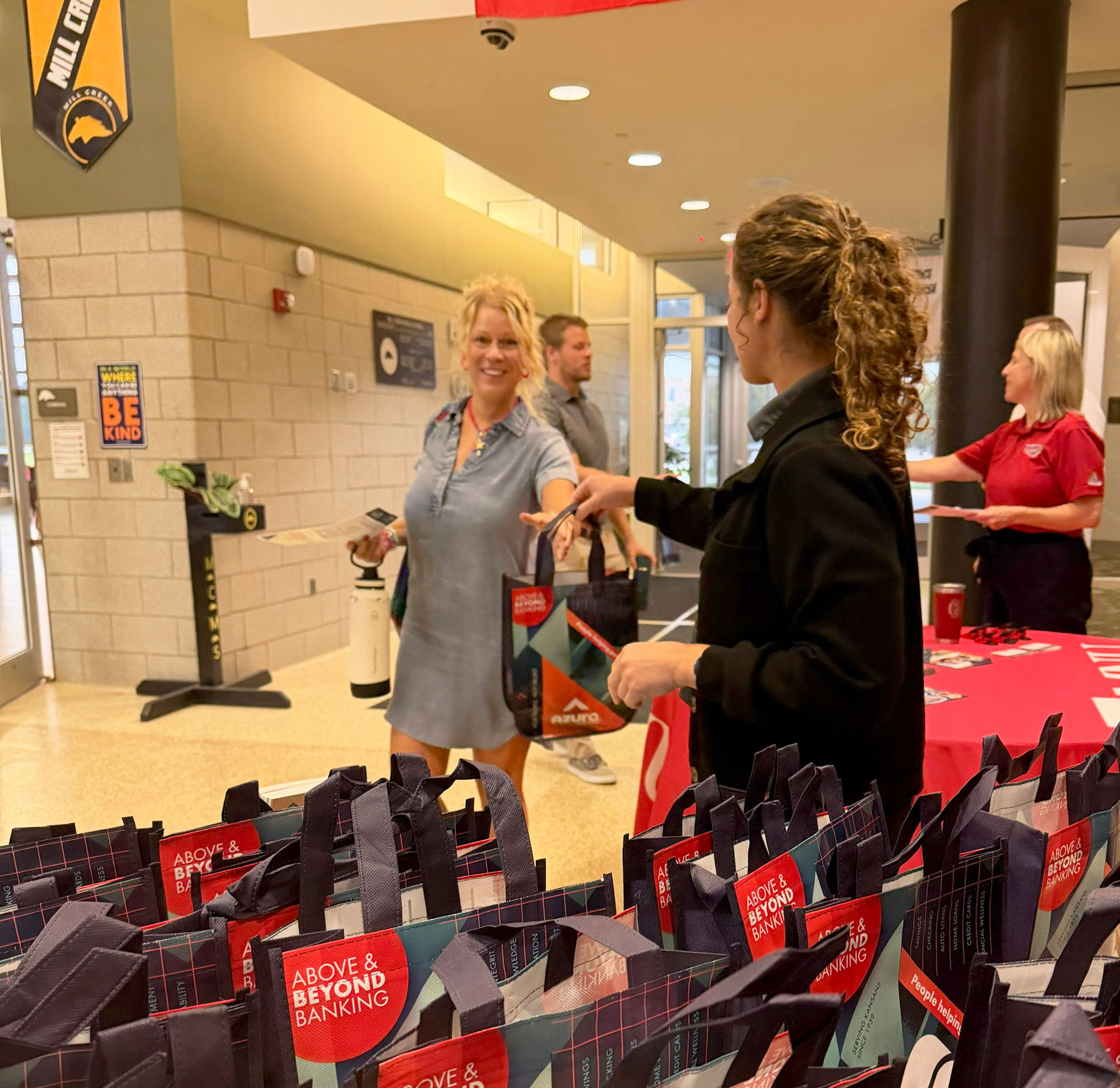 Azura staff handing out gift bag to new school teacher